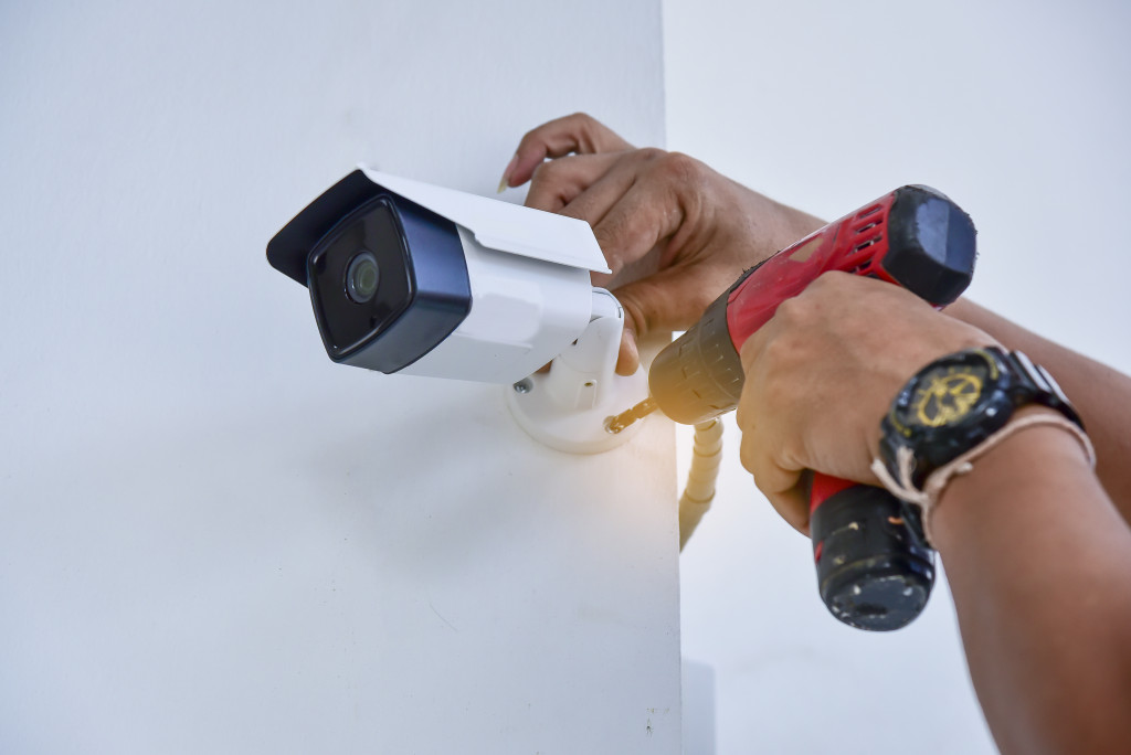 Someone installing a security camera on a wall